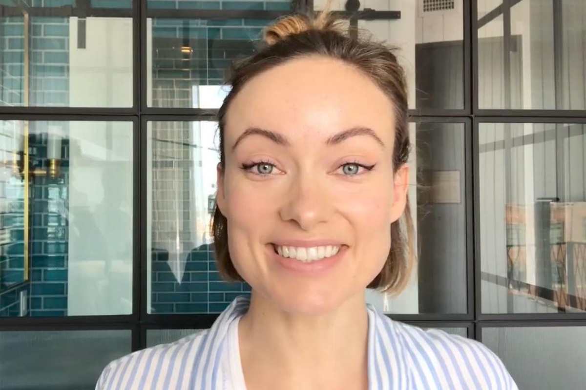 Olivia Wilde sorrindo no banheiro