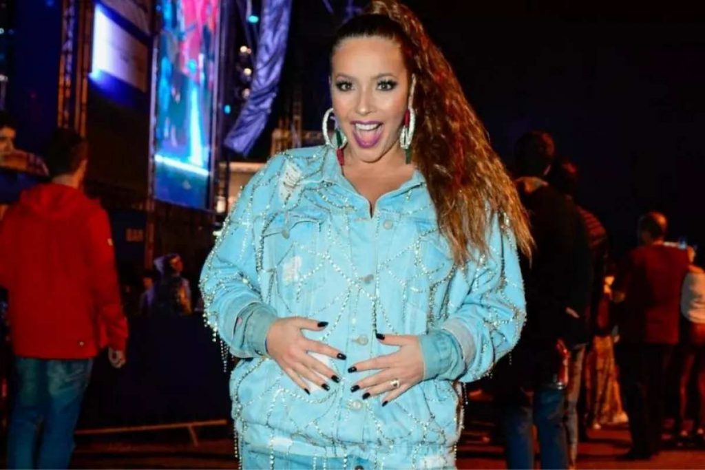 Renata Dominguez com as mãos na barriga de grávida