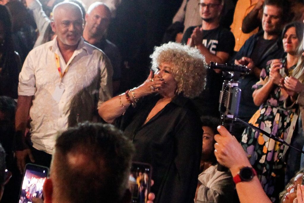 Alcione mandando beijos, de preto, em pé na plateia do teatro