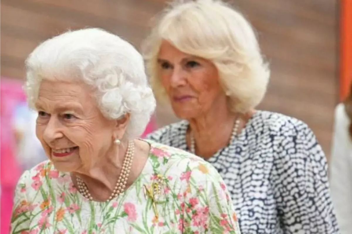 Rainha Elizabeth II, sorridente, acompanhada por Camila Parker Bowles