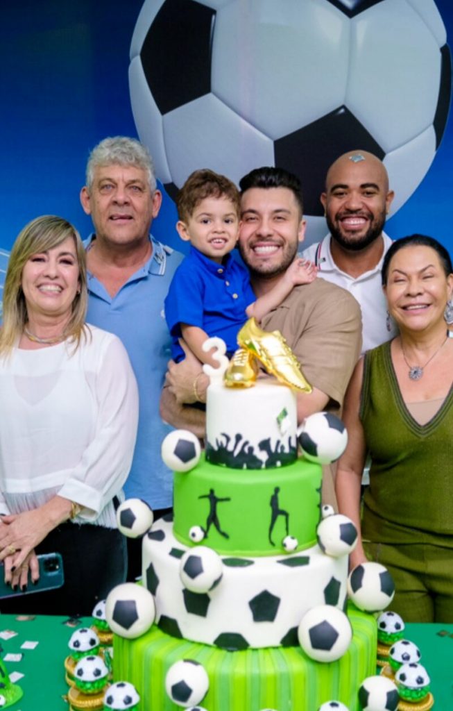 Leo no colo do pai, Murilo Huff, ladeado pelos avós paternos e maternos, diante da mesa de aniversário