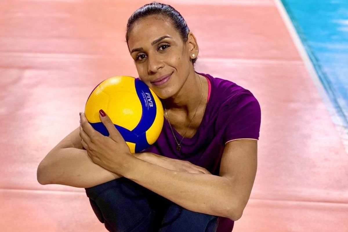 Ana Paula Borgo posando com uma bola de vôlei em uma quadra