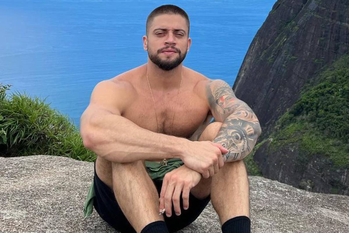 rodrigo godoy sem camisa sentado em uma pedra