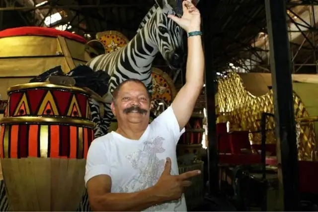 Max Lopes em uma foto, em frente a uma alegoris, no Carnaval
